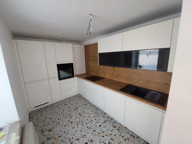 Kuhinja, ki združuje minimalizem, toplino in funkcionalnost.