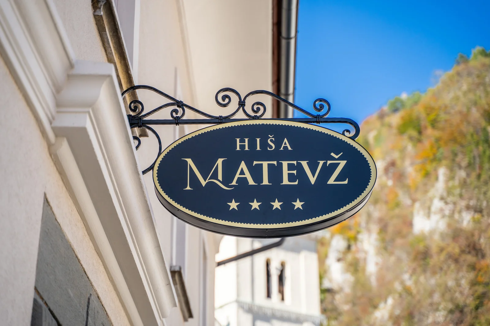 Kovan izvesek Hiše Matevž na fasadi